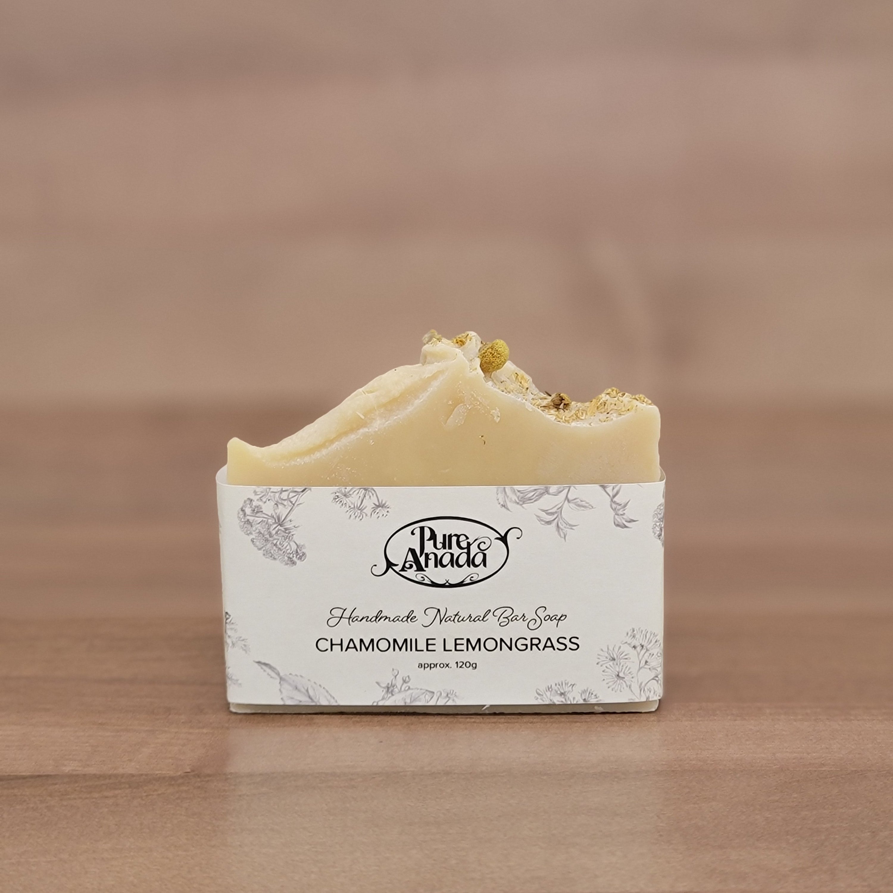 Bar of Pure Anada Chamomile Lemongrass handmade soap with a label on a wooden surface